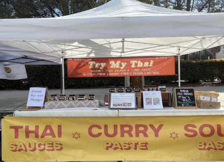 Photo of a vendor tent setup with banner and products.